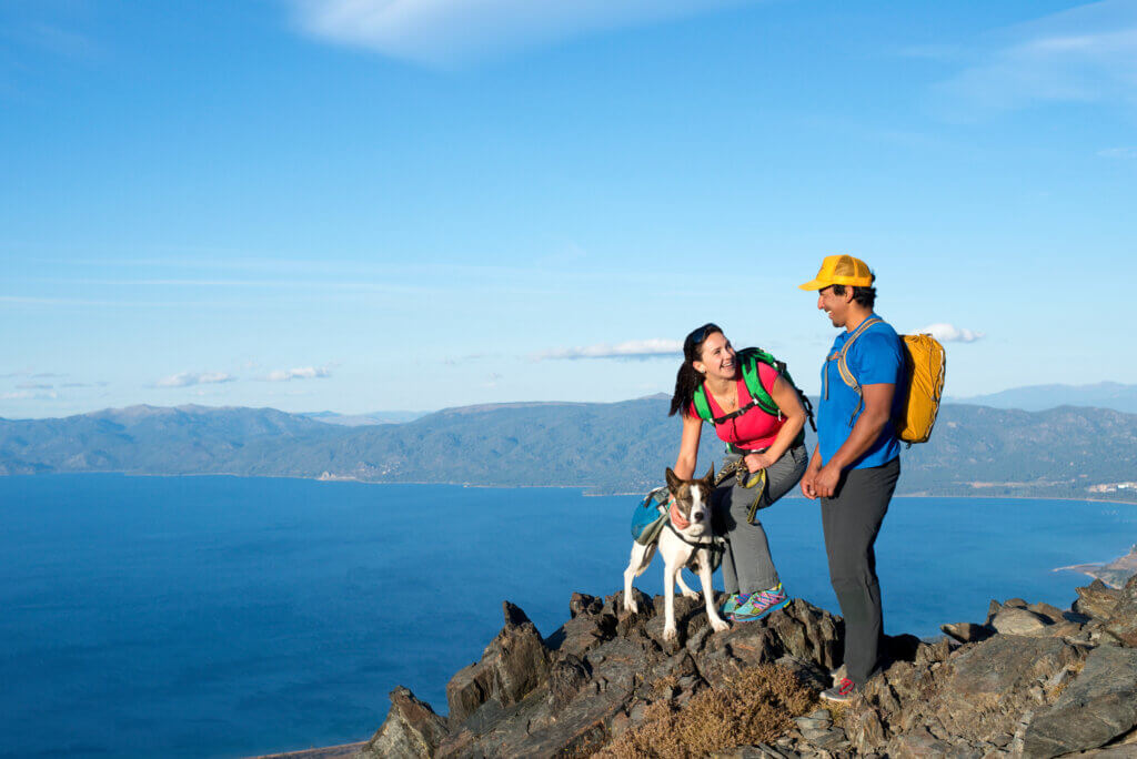 two people and a dog at the summit of Mt. Tallac